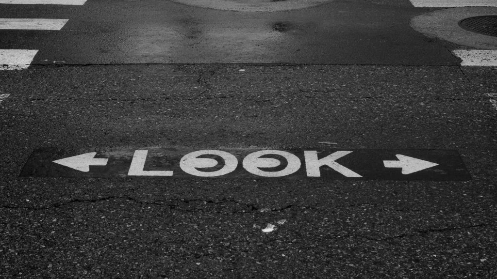 The word "LOOK" painted on a street at a crosswalk